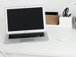 Old generation Macbook on a white desk