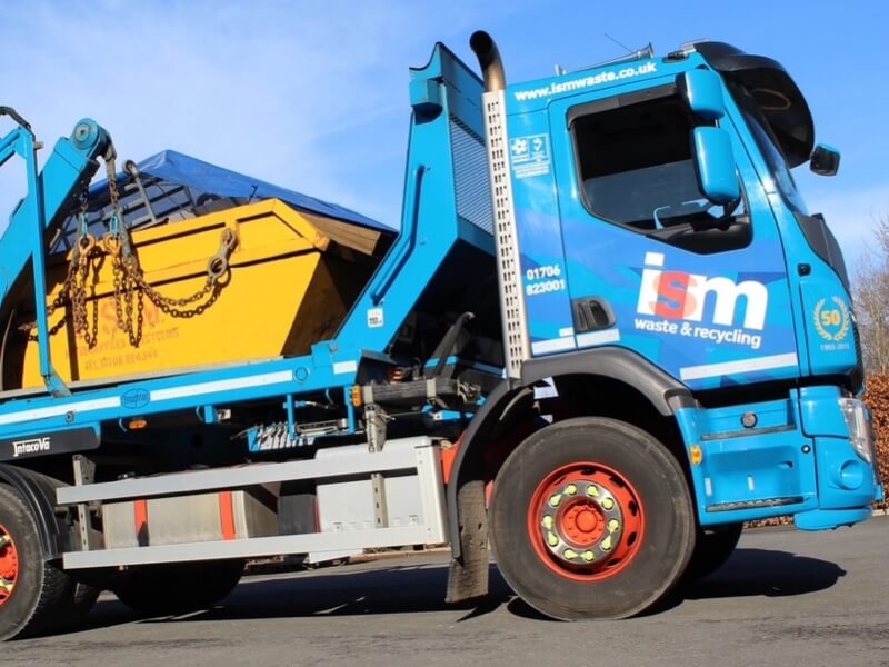 Yellow builders skip on the back of a skip truck