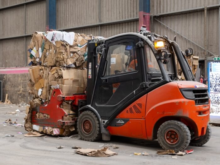 Forklift moving a cardboard bale for recycling